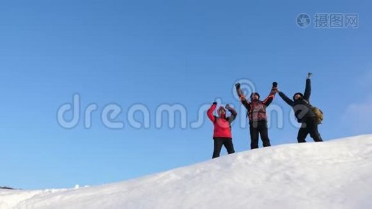 旅行者来到一座雪山的山顶，享受对抗蓝天的胜利。 团队合作和胜利。 团队合作视频