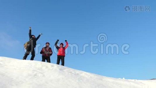 旅行者来到一座雪山的山顶，享受对抗蓝天的胜利。 团队合作和胜利。 团队合作视频