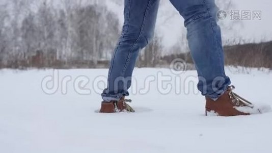 在深雪中行走的脚以慢动作射击。徒步旅行者的脚步在美丽的风景中展现。年轻人视频