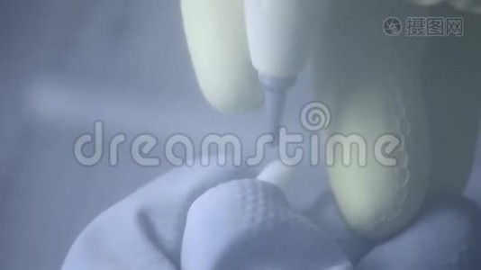 牙科技师在牙科实验室使用砂光机抛光人造陶瓷牙齿。 专业人士戴手套，手提视频