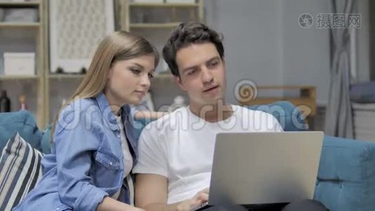 年轻夫妇在家玩笔记本电脑视频
