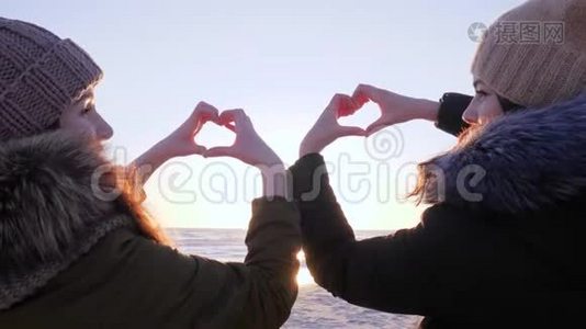女性在海洋和天堂的背景下用手指做心脏视频