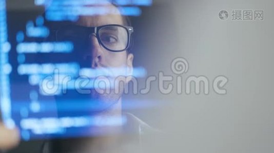 在笔记本电脑上工作的戴眼镜的人黑客程序员的双曝光镜头。 监视器中的反思：开发人员写视频