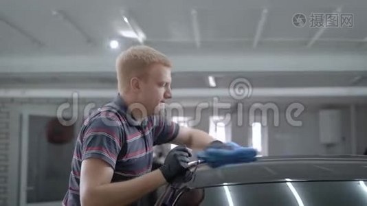 汽车维修师傅在一个工作间用抹布擦拭车顶，抛光视频