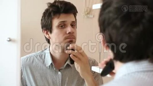 机刮脸发.. 年轻的帅哥用电动刮胡子，张开嘴视频