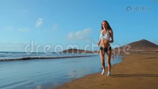 美丽的运动女性沿着美丽的沙滩奔跑，健康的生活方式，在附近享受活跃的暑假视频