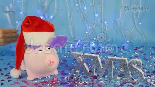 软玩具，粉红色的猪，戴着红色圣诞老人帽子，背景是一棵蓝色的新年树，上面写着视频