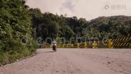 成年男子骑摩托车上路热带森林景观。 夏天骑摩托的老人视频