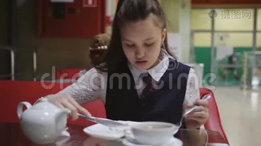 孤独饥饿的女学生休息时在学校食堂吃饭。视频