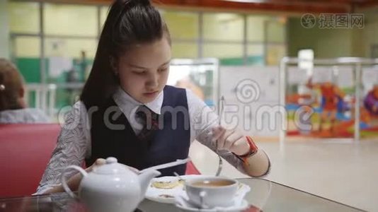孤独饥饿的女学生休息时在学校食堂吃饭。视频