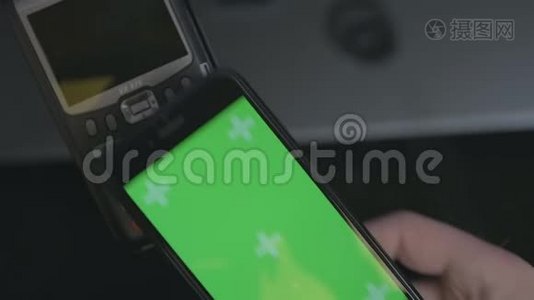 顶部的人使用非接触式支付与智能手机。 手机上的绿色屏幕模板。视频