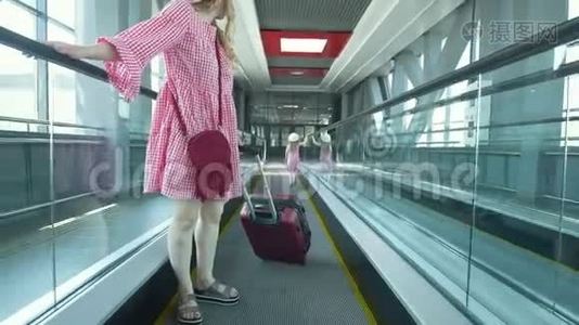 年轻漂亮的女人带着手提箱从扶梯上下来，她漂亮的女儿在门口追赶她的母亲视频