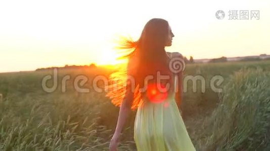夕阳西下的夏日，穿着黄色衣服在麦田里奔跑的年轻美女，自由健康幸福的理念视频