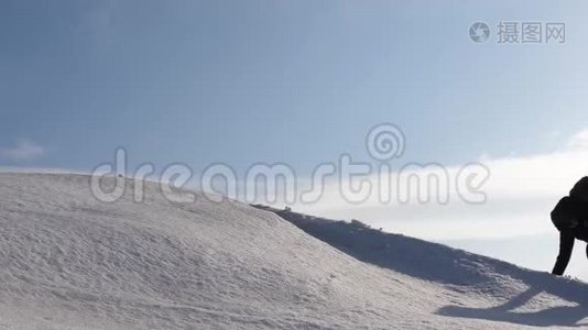 登山者手牵手爬到雪山顶上。 冬天的旅行者团队要达到克服困难的目标视频