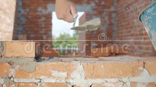 砌砖工人的特写镜头把墙砌成房子视频