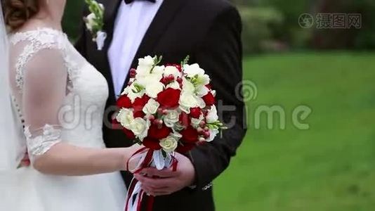 婚礼当天，新郎抚摸新娘`手，婚礼花束视频