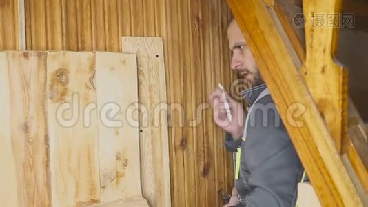 工人在木制内部设置自制门.. 用尺子测量，门口和门。视频