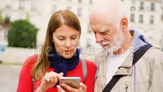 年长的父亲和他的小女儿站在街上使用智能手机。 幸福的家庭视频