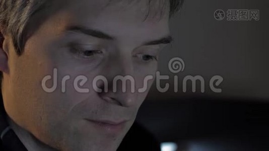 一个男人晚上在用笔记本电脑工作视频