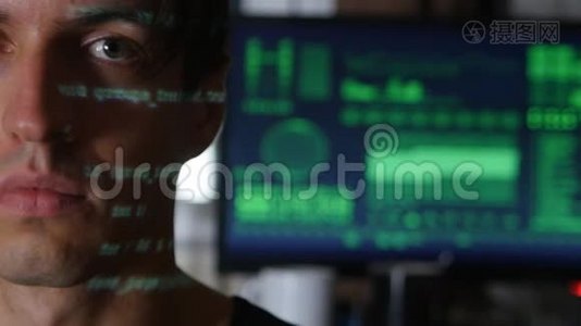 带有绿色代码字符的人程序员黑客肖像在他的脸上，背景是一台计算机视频
