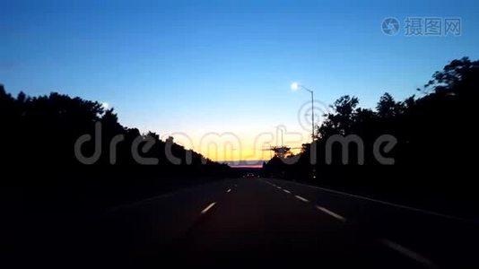 在日出期间驾驶乡村公路。 当太阳清晨在地平线上升起时，司机的视角POV。视频