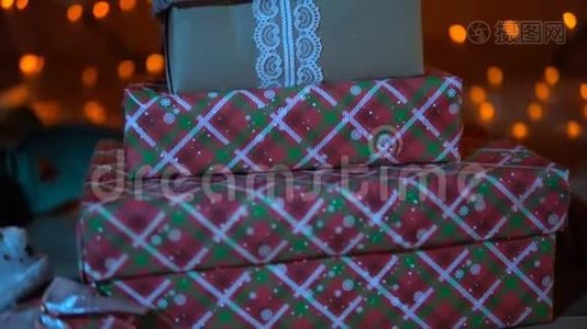 礼物在圣诞树下的背景花环在晚上，特写。视频
