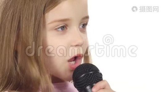 小女孩把歌唱到麦克风里。 白色背景。 关门视频