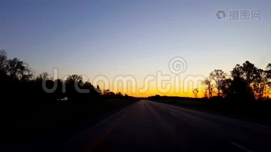 在日出期间驾驶乡村公路。 太阳清晨在地平线上升起时的驾驶视角视频
