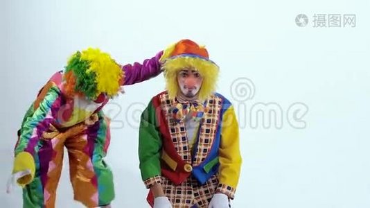 两个快乐小丑的特写镜头其中一个在另一个小丑周围向后跳跃视频