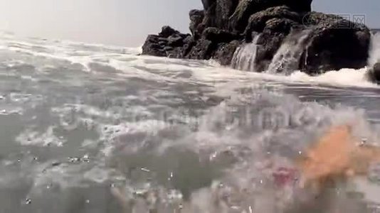 十几岁的男孩游泳，爬上岩石。视频