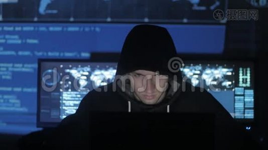 一个在电脑上工作的黑客，而蓝码人物则在网络安全中心的面部表情视频