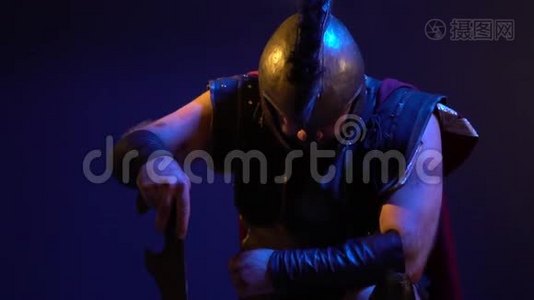 身穿盔甲和头盔的罗马士兵正跪在剑上视频