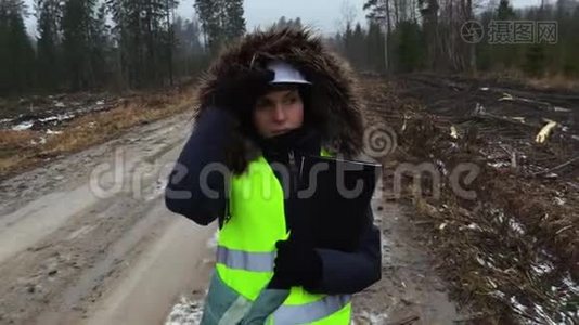 在潮湿的冬日里，女林业雇员散步和讲述视频