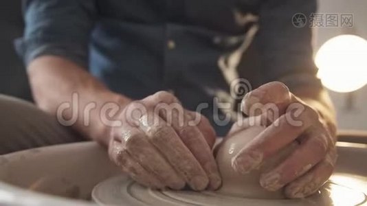 男人`手，沾上泥土，用陶工`轮子干活视频