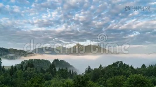 云在蓝天上移动，幻山在雾蒙蒙的晨谷中出现视频