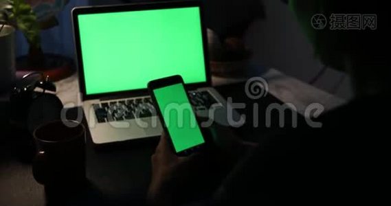 使用智能手机和带有绿色屏幕的笔记本电脑。 多利在视频