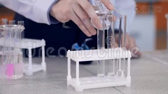手将化学试剂加入小瓶，试管中.. 学生在实验室做化学测试。视频