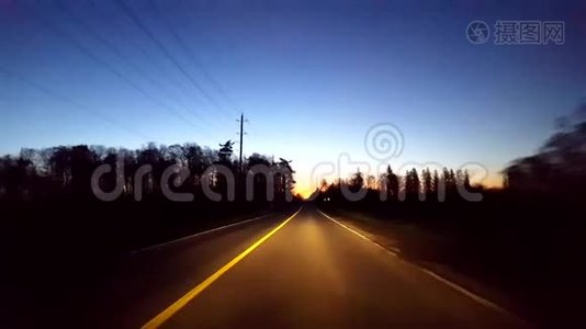 日出时分，驱车行驶在乡村公路上。清晨太阳升起时驾驶员视角视频