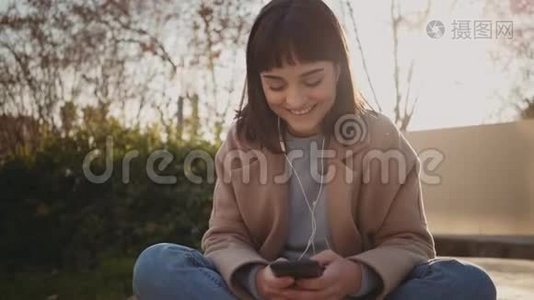 漂亮的女人在公园里使用智能手机视频