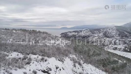 用树木和道路俯瞰雪山景观。 中枪。 雪林中道路的俯视图视频