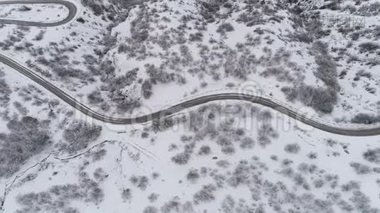 用树木和道路俯瞰雪山景观。 中枪。 雪林中道路的俯视图视频