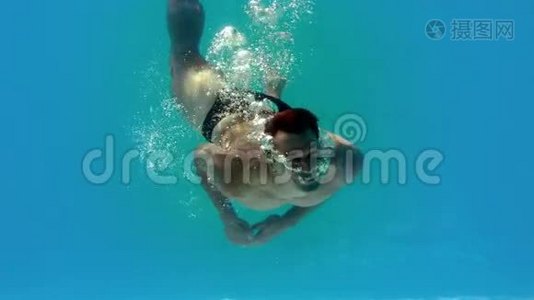 健身男子在游泳池的水下旋转视频