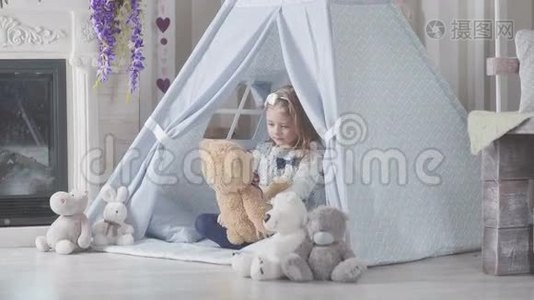 一个金发碧眼的小女孩坐在柔软的玩具周围视频