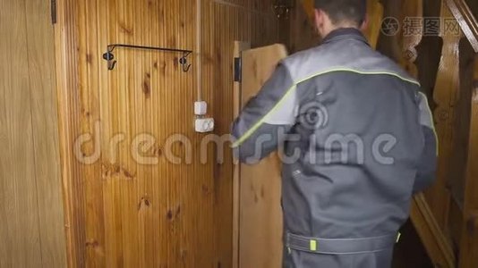 这位工人在木制的室内设置了一扇自制的门视频