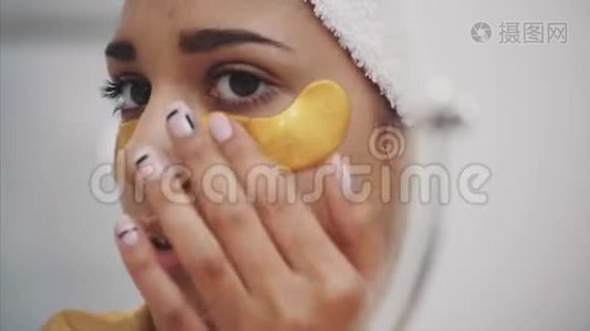 一幅美丽女人洗澡后用毛巾在头上的特写肖像，将皱纹贴在眼睛下面视频