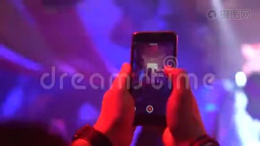 男人用智能手机录制音乐会视频