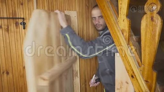 这位工人在木制的室内设置了一扇自制的门视频