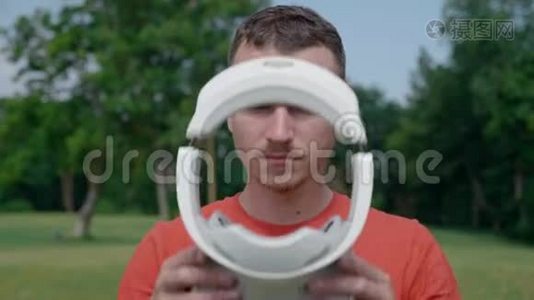 公园里一个男人把VR耳机戴在头上视频