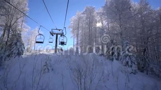 滑雪缆车上的雪林和滑雪者视频