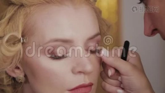 专业化妆师将模特化妆照片应用于女性。视频